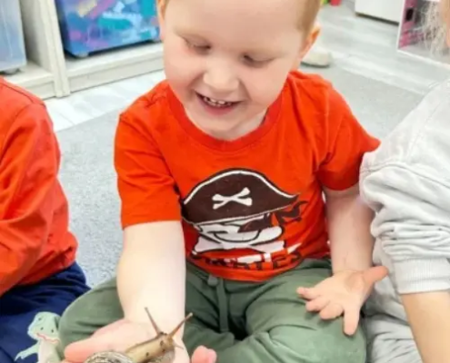 Dzieci patrzące na dużego ślimaka