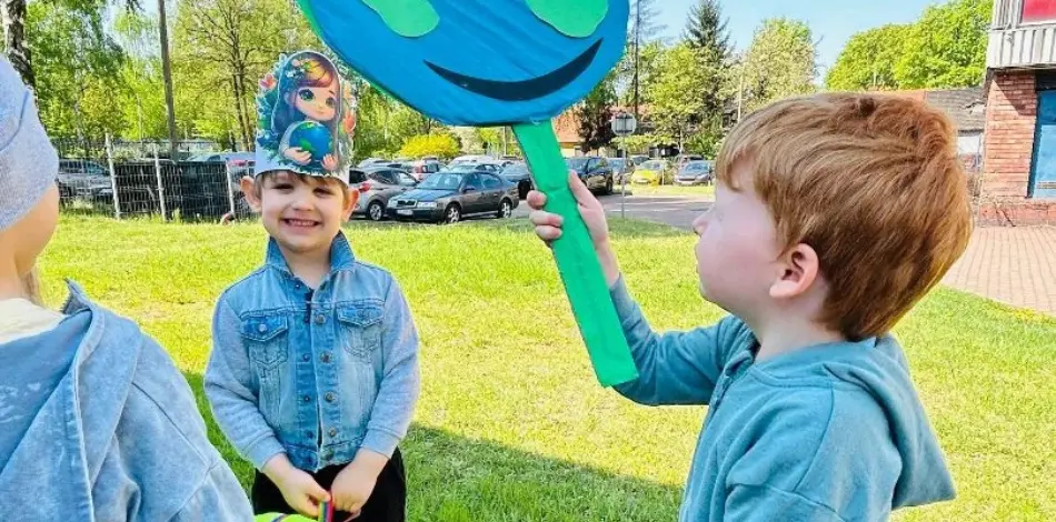 Chłopcy przechodzący obok parkingu samochodowego